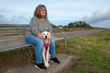 woman on bench with emotional support animal, english cream golden retriever